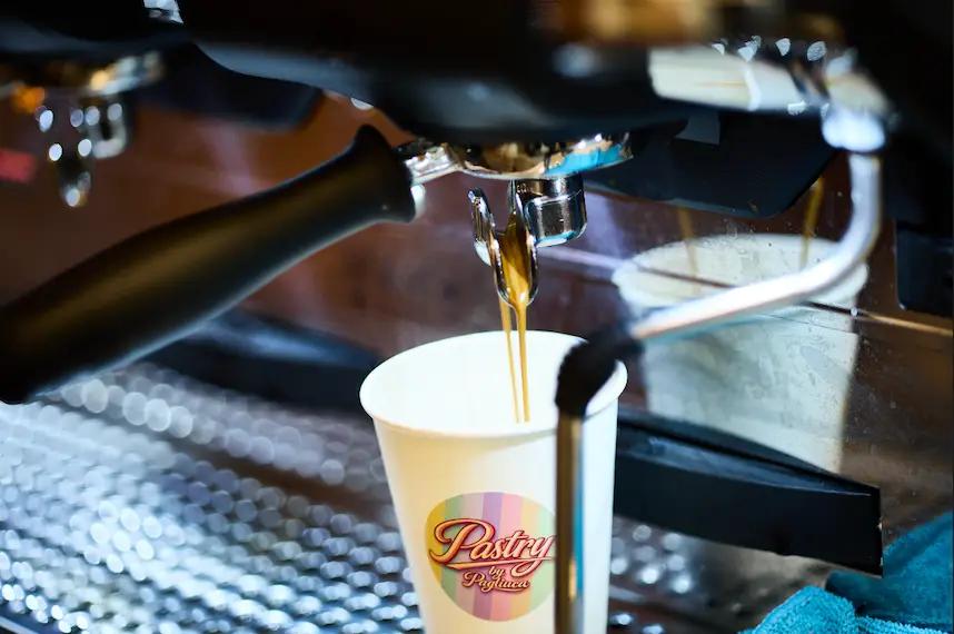 Kaffe brygges i kaffemaskine ned i kop med Pastry by Pagliuca logo